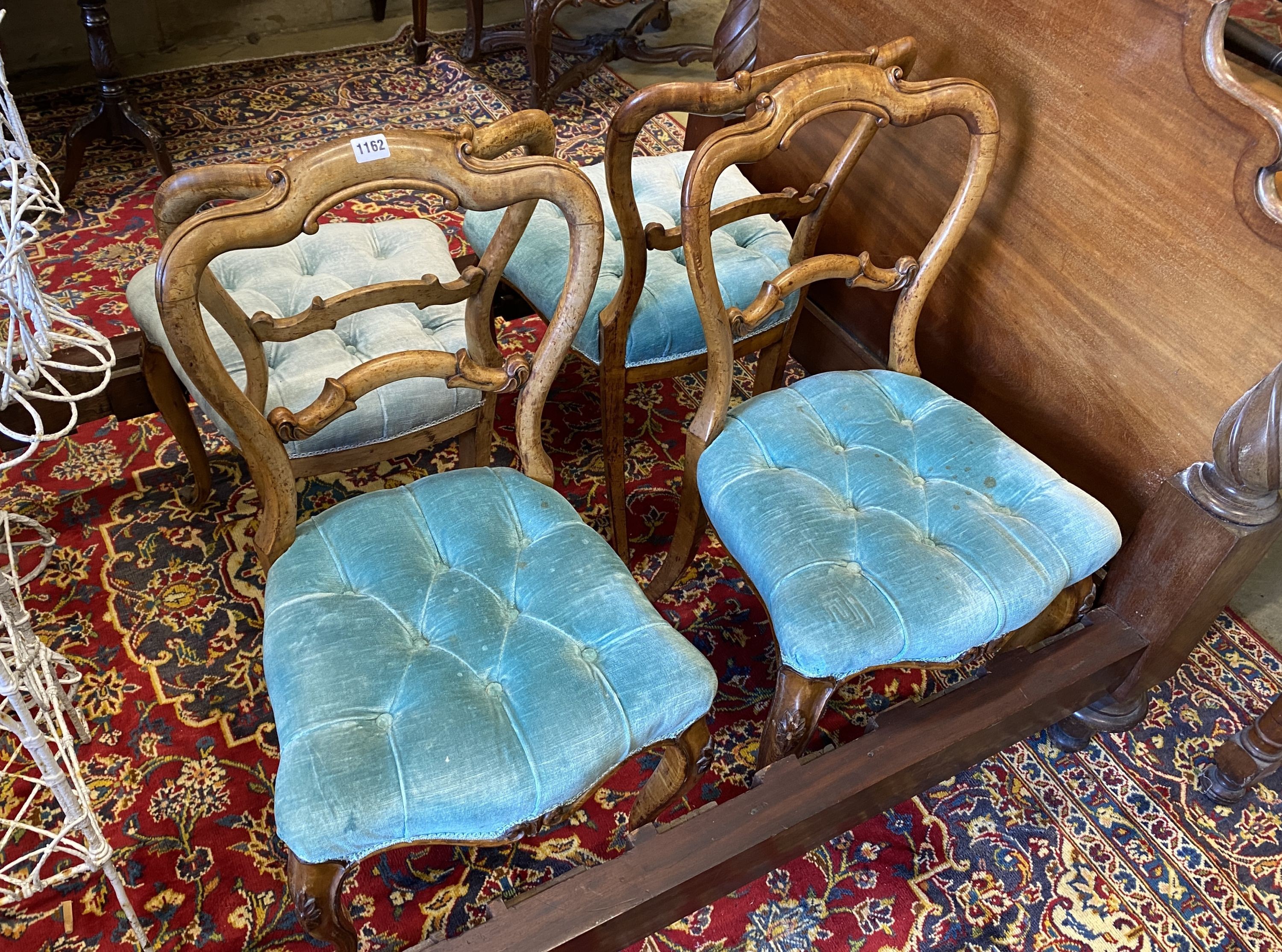 A set of four Victorian walnut balloon back upholstered dining chairs